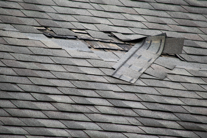 A badly damaged roof with missing shingles in need of repair in detroit