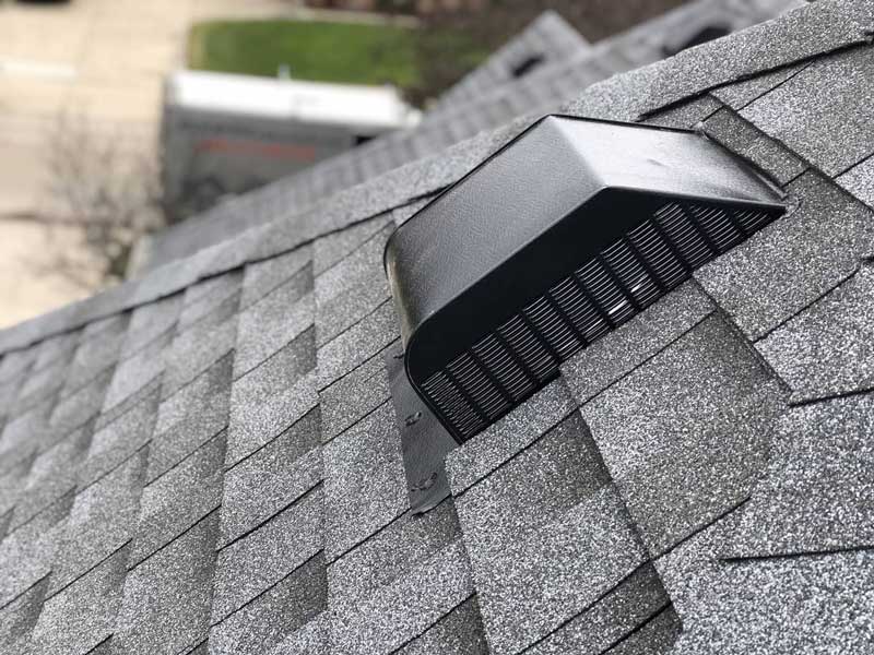 A roof exhaust vent on an asphalt roof.