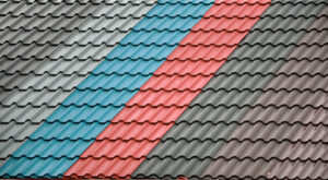 Architectural background. Texture of a metal roof tiles of black, blue and red colors.