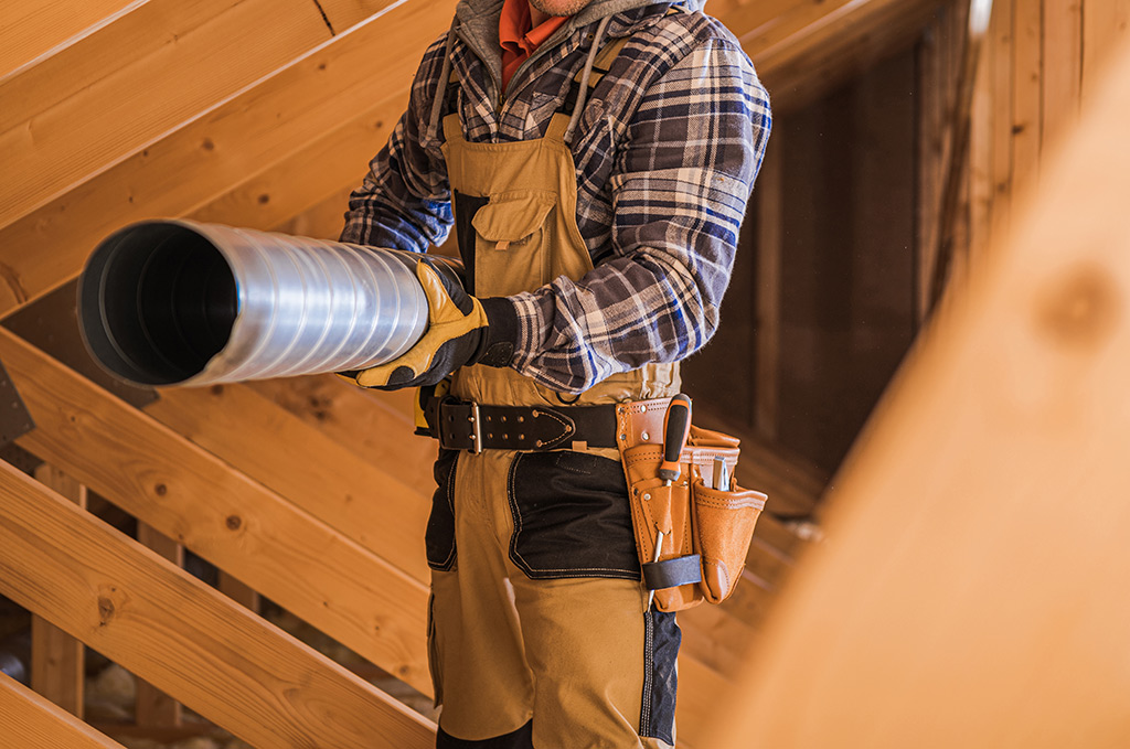 worker installing hvac in attic