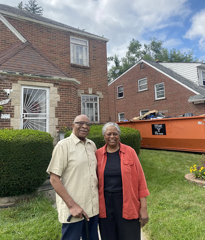 older couple in front of old house