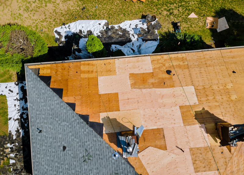 Workers putting plywood, underlayment and shigles
