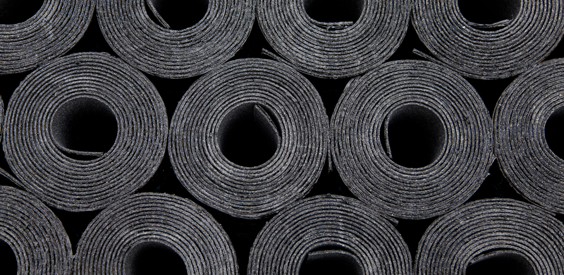 Rolls of roof coating. Rolls of new black roof coating or bitumen. Front view roofing felt